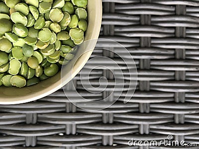 Plate with green peas on a dark wicker texture. Stock Photo