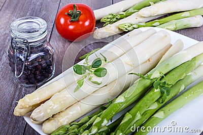 Plate with green and white asparagus, spices and tomato Stock Photo