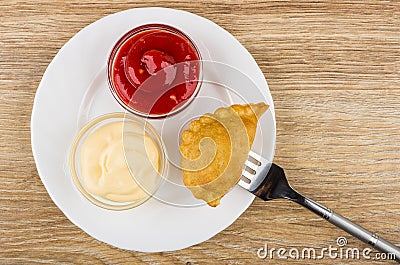 Plate with ketchup and mayonnaise and cheburek strung on fork Stock Photo