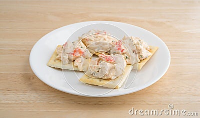 Plate of lobster dip on saltine crackers on a wood table Stock Photo