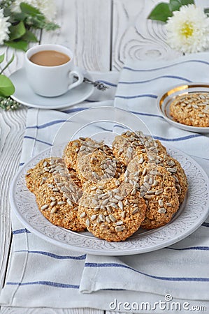 On a plate oatmeal cookies with seeds, white light wooden background Stock Photo