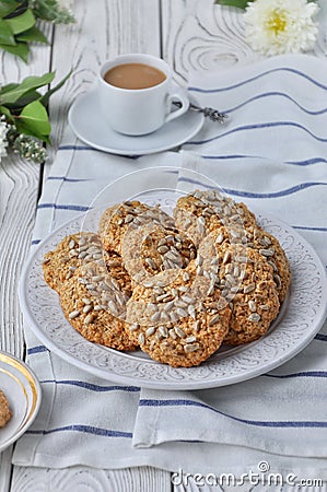 On a plate oatmeal cookies with seeds, white light wooden background Stock Photo