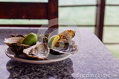 A plate of oysters served with lime Stock Photo