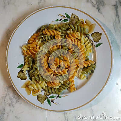 On the plate is a portion of multi-colored spirals. View from above Stock Photo