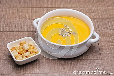 Plate with pumpkin soup with seeds and crackers Stock Photo