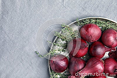 Plate with ripe red onions on fabri Stock Photo