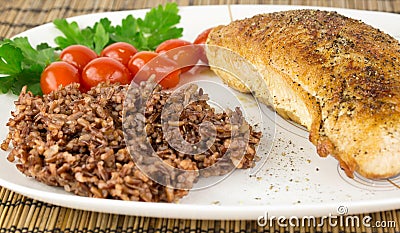 Plate with roast turkey with brown and red rice and whole cherry Stock Photo