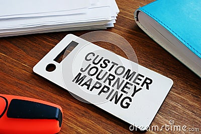 Plate with sign Customer journey mapping and papers with map Stock Photo