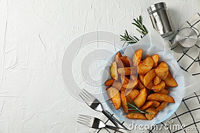 Plate of sliced baked potato wedges, salt, forks on white background, top view. Space for text Stock Photo