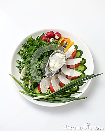 Plate with spring salad. Assorted fresh herbs and vegetables with soft cheese isolated on white background Stock Photo