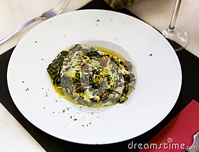 Plate stewed spinach with jamon at plate, nobody Stock Photo