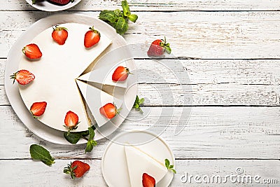 Plate with tasty cheesecake with strawberries and mint on a wooden background. Stock Photo