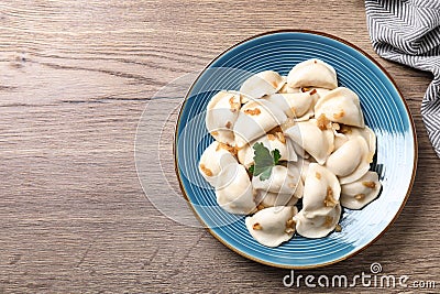 Plate of tasty cooked dumplings on wooden table, top view Stock Photo