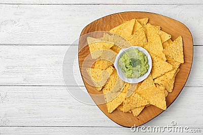 Plate with tasty Mexican nachos and guacamole sauce on white wooden table, top view. Space for text Stock Photo