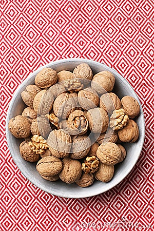 Plate with tasty walnuts on color napkin Stock Photo