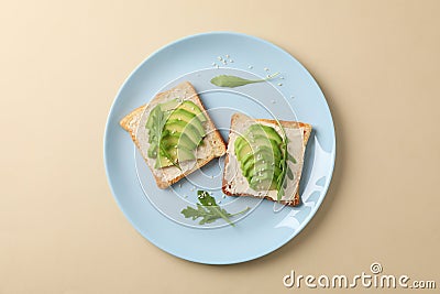 Plate with toasts with avocado, arugula and sesame on beige background Stock Photo