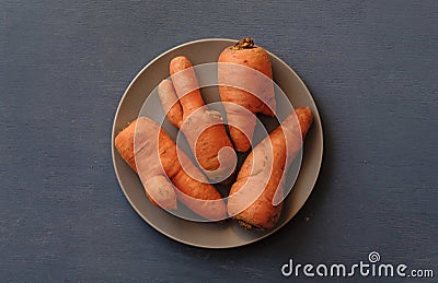 Plate with ugly carrots from above Stock Photo
