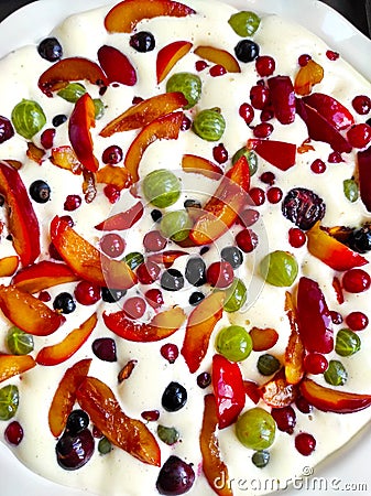 Plate of uncooked clafouti with berries and fruits Stock Photo