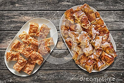 Plateful of Serbian Traditional Crumpled Cheese Pie Gibanica and Spit Roasted Pork Meat Slices Set on Old Weathered Garden Table Stock Photo