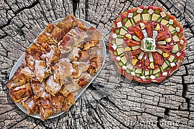 Plateful of Spit Roasted Pork Slices And Appetizer Savory Dish Meze On Old Wooden Picnic Table Stock Photo