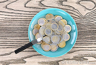 Plates full of euro coins and magnifiers Stock Photo