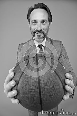Play basketball be happy. Happy businessman hold basketball ball. Basketball coach grey background. Basketball coaching Stock Photo