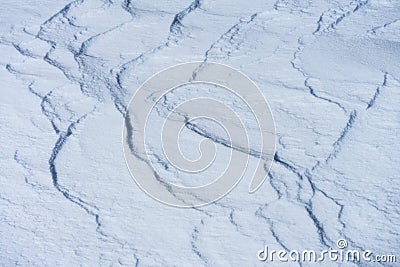 The play of light and shadow on the undulating slopes of white snowdrifts. The snow surface in the background lighting. Stock Photo