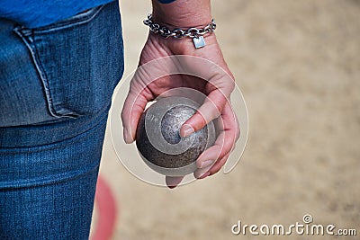 A player holds in hand a boule for petanque Stock Photo