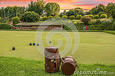 Player playing Lawn bowls in a lush green field with leather bags on the side Stock Photo