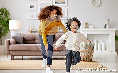 Playful afro american family mother and son running and playing in living room at home Stock Photo