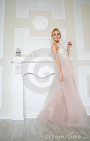 Playful bride with blond hair smiles and walks to the side Stock Photo