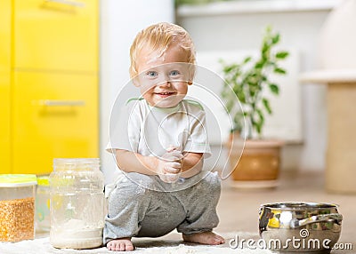 Playful child boy with face in flour surrounded Stock Photo