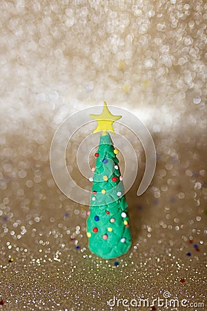 Playful clay christmas concept. Colorful handmade miniature Christmas tree in gold background Stock Photo