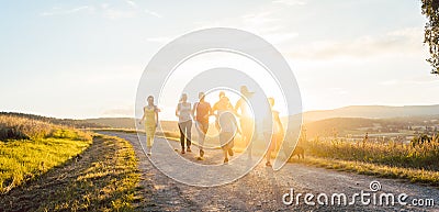 Playful family running and playing on a path in summer landscape Stock Photo