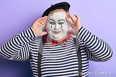 Playful funny plump man touching his face with fingers looking at the camera Stock Photo