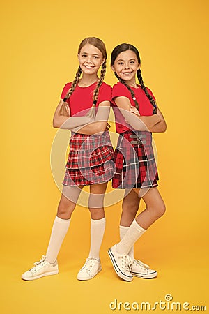 Playful kids. Happy small girls wearing same outfits. Friends enjoying friendship. Happy together. School friends having Stock Photo