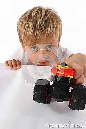 An adorable fair hair child boy peeking underneath a block Stock Photo