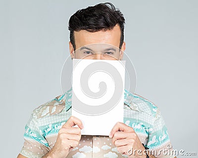 Playful man covers half the face with a blank rectangular cartel Stock Photo