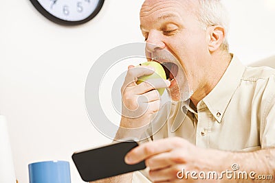 Playful man savors green apple's health qualities Stock Photo