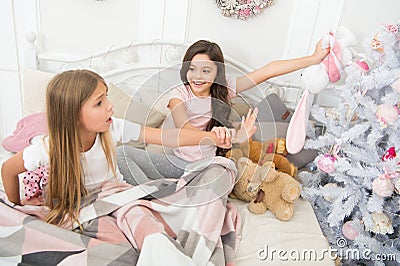 In playful mood. Naughty children. Small children have fun at christmas tree. Little children play fool in bed Stock Photo