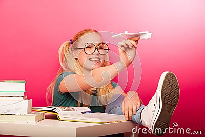 Playful, naughty schoolgirl with big eyeglasses throwing paper a Stock Photo