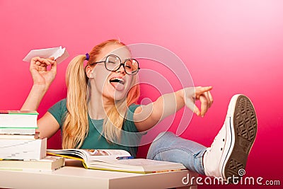 Playful, naughty schoolgirl with big eyeglasses throwing paper a Stock Photo