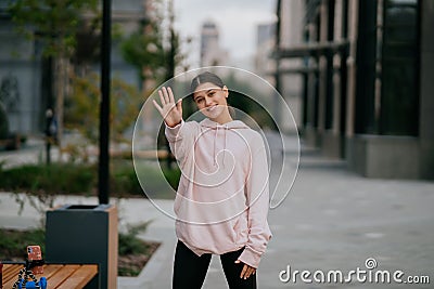 Playful portrait of pretty young woman, having fun at the street. Stock Photo