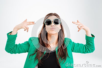 Playful pretty young woman in round sunglasses pointing on herself Stock Photo