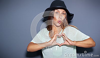 Playful romantic young woman making a heart sign Stock Photo