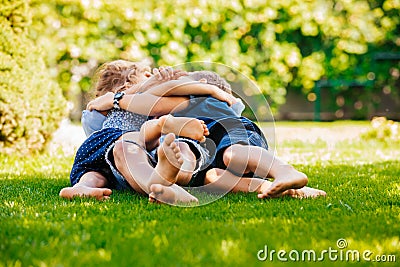 Playful siblings having fun on a green lawn Stock Photo