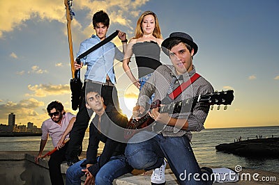 Playful teenage musical band posing at sunset Stock Photo
