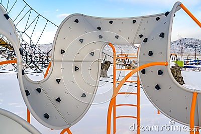 Playground with curvy climber against snow and sky Stock Photo