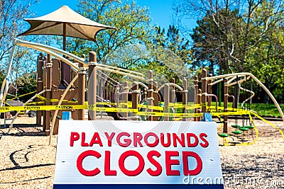 Playgrounds closed sign with blurred outdoor children playground Stock Photo