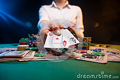 Playing in a casino, online casino. A player opens cards with two aces. Money, poker table, chips. Background for the gaming Stock Photo